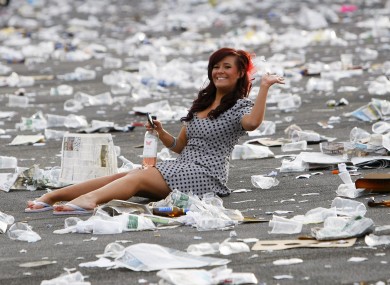 A racegoer sits amongst the rubbish after Aintree Ladies Day last year.