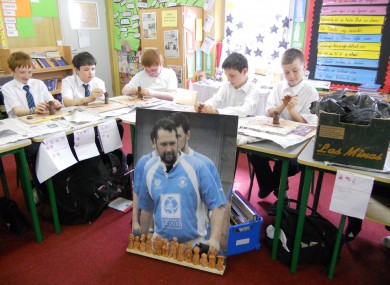 Schoolchildren contribute terracotta figurines to the Pitch for Shane project, in front of a portrait of the murdered rugby player.