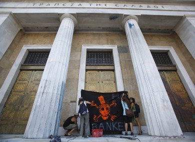 Protesters place a placard on the door of Greece's Central Bank, during an anti-austerity protest in Athens
