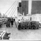 Passengers take the air on deck of the Titanic - passing by the lifeboats, of which there were too few to accommodate everyone when the ship sank.