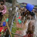A supporterof Indian yoga guru Baba Ramdev bathes at the venue of a protest in New Delhi, India. Indian yoga guru Baba Ramdev, who is on his third day of fasting, deferred announcement on the next course of his action to pressure the government to bring back billions of ill-gotten gains. (AP Photo/Altaf Qadri)