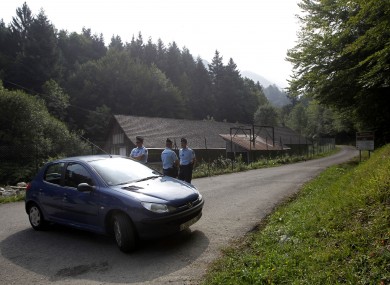 A gendarme blocks access to site where people were shot to death near Chevaline.