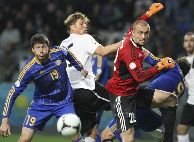 Kazakhstan's Viktor Dmitrenko, left, Austria's Sebastian Prodl, center, and Kazakhstan's goalkeeper Sergei Ostapenko, right, struggle for the ball.