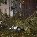 A fallen tree branch sits on a car blocking East 74th St. between Lexington Avenue and Third Avenue on Manhattan's Upper West Side on Monday. Sandy made landfall Monday night, hurling a surge of seawater on New York City with wind and rain that sent water sloshing into Manhattan from three sides but began dying down within hours. (AP Photo/Willie Regan)