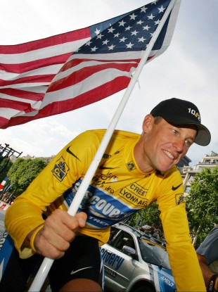 Armstrong carries the US flag during a Tour de France victory parade. (file photo)