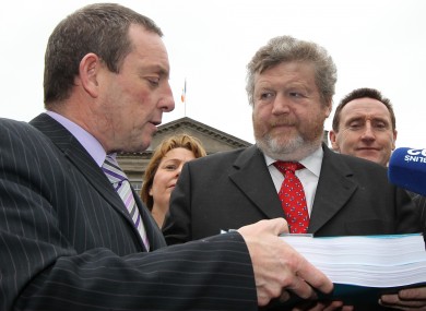 Jerry Buttimer gives James Reilly his committee's report following its first hearings in January. A second report, extending to over 1,600 pages, has been handed over today.