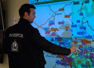 An Interpol officer looks at map where seizures have taken place