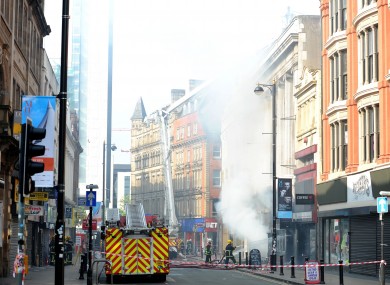 Firefighters at the scene of a fire at Paul's Hair World in Oldham Street, Manchester, where firefighter Stephen Hunt, 38, was killed whilst tackling the blaze at the city centre shop.