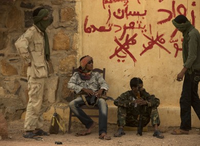 Rebels from the National Movement for the Liberation of the Azawad (NMLA) stand guard outside the former governor's office, in Kidal, Mali.