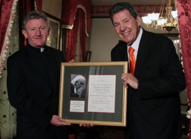 Fr Devine, pictured receiving the 2013 International Caring Award from Mr Val Halamandaris, Founder and Executive Director of the Caring Institute