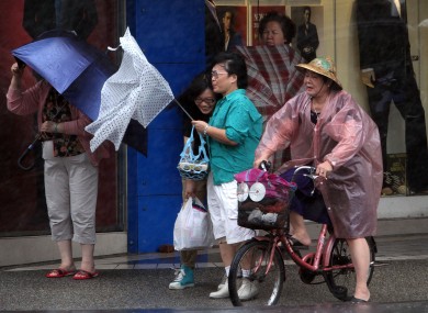 Taiwanese women hold their umbrellas against powerful gusts of wind as Typhoon Fitow approaches in Taipei.